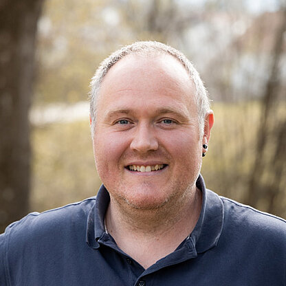 Mitarbeiterfoto vor grünem Hintergrund