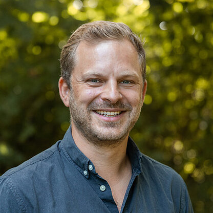 Mitarbeiterfoto vor grünem Hintergrund