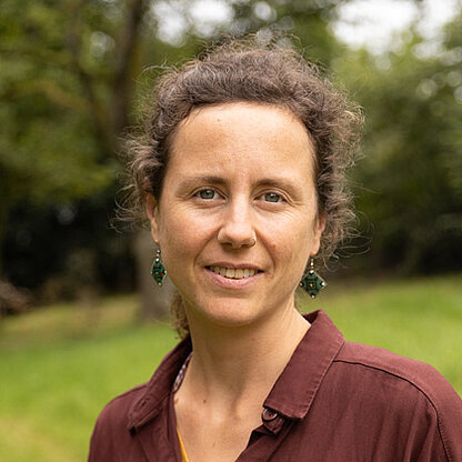 Mitarbeiterfoto vor grünem Hintergrund draußen