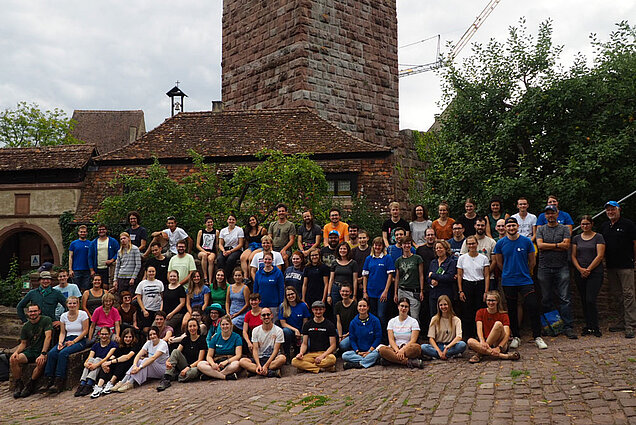 Gruppenfoto des Artenkenntnis-Wochenendes in Rothenfels (Foto: Franziska Tank) Eine große Gruppe von Jugendlichen sitzt und steht vor einem mittelalterlichen Turm.