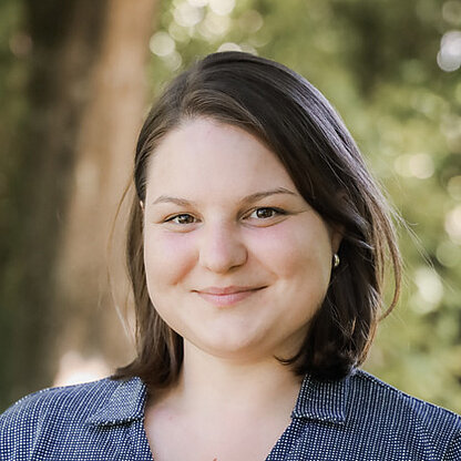 Mitarbeiterfoto vor grünem Hintergrund draußen